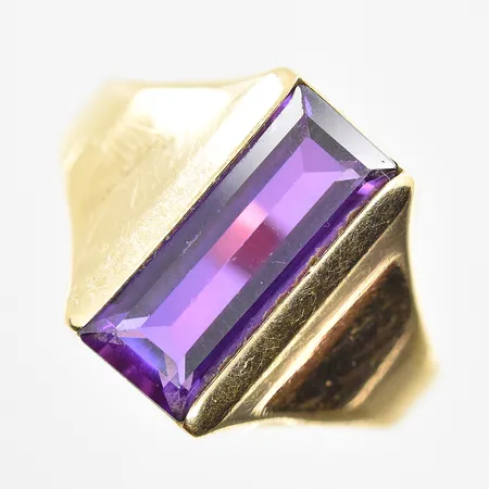 Ring med lila sten stl:19½, bredd 3-15 mm, 18K. Vikt: 4,4 g