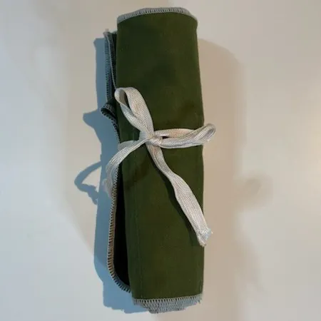 Besticklinda plats för 12 bordsbestick, grön filt, vita band.