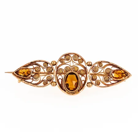 Brosch med filigrandekor och orangea stenar, bredd 40mm 18K 3,3g.