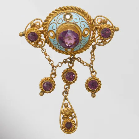 Brosch med emalj samt plastdetaljer, längd ca 60mm, bredd 45mm, gulmetall.