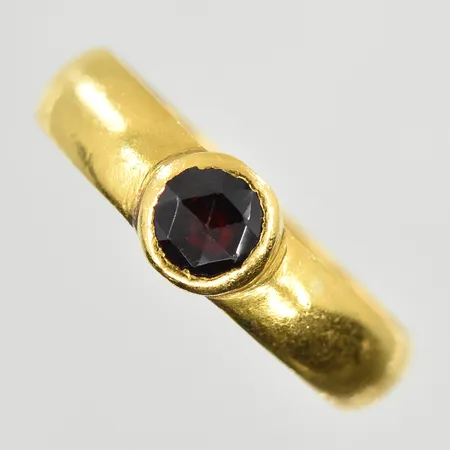 Ring med röd sten, stl 17¾, bredd 4 mm, skev skena, 23K. Vikt: 5 g