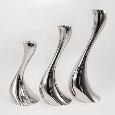 Tre Ljusstakar Georg Jensen Cobra av Constantin Wortmann, höjd 16cm, 20cm samt 24cm polerat rostfritt stål, smärre bruksslitage, inga tillbehör Skickas med postpaket.