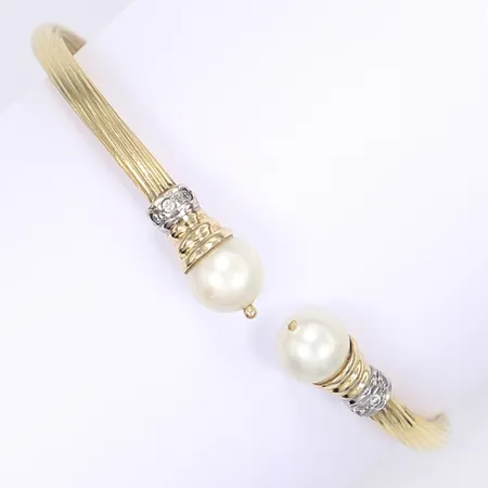 Stelt armband med syntetiska pärlor och vita stenar ca 66x60mm innermått 61x50mm 14K Vikt: 12,7 g