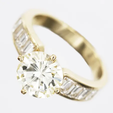Ring briljantslipad diamant ca 2,60ct Light Yellow (R-S)/VS2 samt 12 baguetteslipade diamanter totalt ca 1,00ctv ca TW-W/VS-SI, stl:17¼, briljant med nagg vid rondisten en baguett med nagg värderingsintyg från Kaplans Vikt: 5,4 g