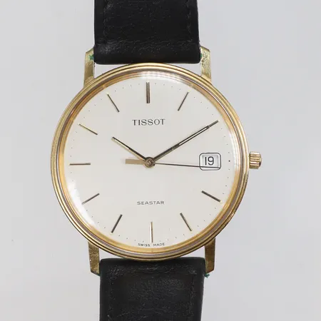 Herrur Tissot Seastar 18K Ø34mm gravyr, datum, quartz (går ej, troligen batteribyte), med slitet läderband, guld i boett bruttovikt 30,7g