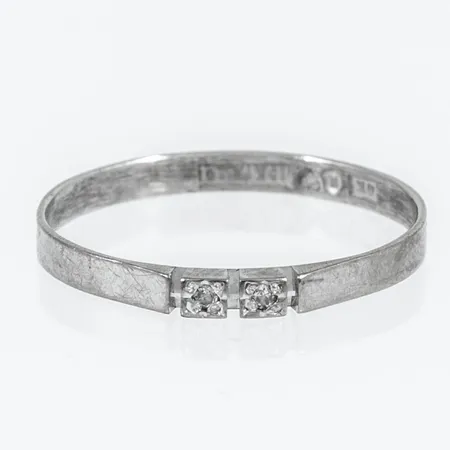 Ring i 18K vitguld med två diamanter á ca 0,005ct (8/8-slipade). Den är 2 mm bred, stl:17¼ och väger 1,0g.