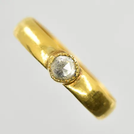Ring med vit sten stl 19¼, bredd 4 mm, slitna fasetter, gravyr, 23K. Vikt: 3,4 g
