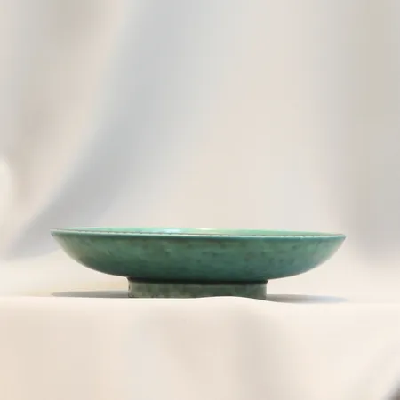 Skålfat Argenta Wilhelm Kåge för Gustavsberg, grönt glaserad keramik med silverdekor av get Ø18,5cm höjd ca 4cm, P1 årsbokstav G= 1937, smärre slitage, glasyrsprickor  Skickas med postpaket.