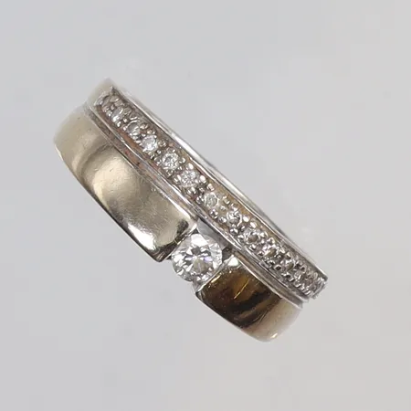 Ring med diamanter ca 1x0,15ct samt 15x0,01ct stl:18, bredd 4-6mm, vitguld, GHA, sliten, 18K Vikt: 6 g