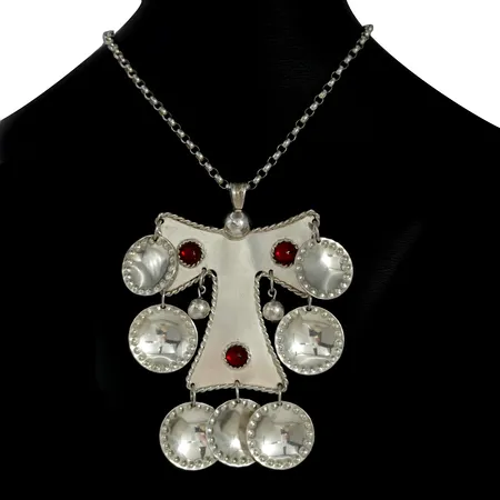 Striglakors med tillhörande halskedja, silver, röda glasfluss, allmogestil, 1900-tal, höjd från ögla till nedersta del på dekor 9,5 cm, kedja längd 60 cm, bredd 3,5 mm, kedja ej öppningsbar, stenar utan anmärkning, fint skick, sparsamt använd, kontrollstämpel  Vikt: 60,3 g