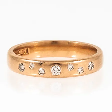 Ring med sju briljantslipade diamanter totalt 0,11ct stl:16 bredd 3,5mm, höjd 1,5mm 18K 3,5g. 