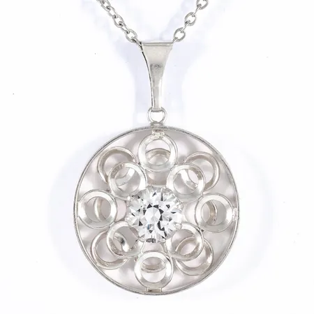 Finskt hänge i silver med en vit sten. Det är Ø 30,6 mm, 46 mm långt inkl. ögla. En 48 cm lång kedja i silver medföljer. Vikt: 12,1g.