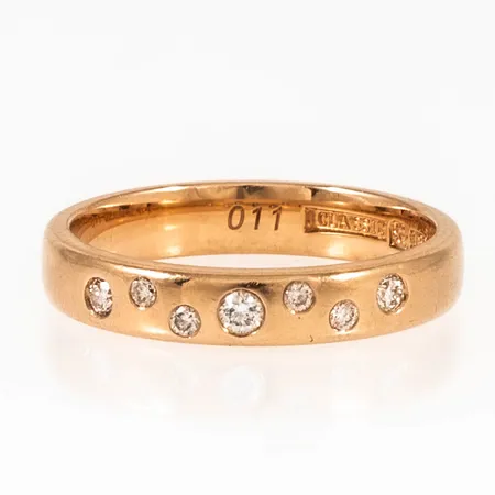 Ring med sju briljantslipade diamanter totalt 0,11ct stl:15¾ bredd 3,5mm, höjd 1,5mm 18K 3,5g. 