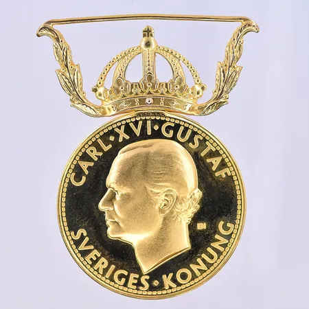 Medalj längd 41 mm, Ø27 mm 23K. Vikt: 14 g
