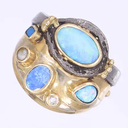 Ring med diamant 1x ca 0,03ct samt skimrande stenar troligen opaler, missformad skena ca stl:20, bredd 6-23mm, tillverkad i 18K och blyliknande material, 18K Bruttovikt: 15,8g Vikt: 15,8 g