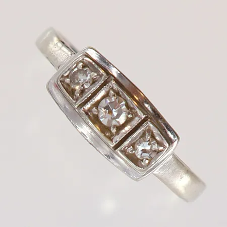 Ring med 8/8-slipade diamanter 1 x 0,05ct 2 x  0,02ct stl:15½ bredd 1,4-5,3mm vitguld 18K.  Vikt: 2,1 g