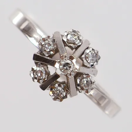 Ring med 8/8-slipade diamanter 7 x 0,02ct stl:17½ bredd 2-8,5mm vitguld 18K.  Vikt: 2,5 g