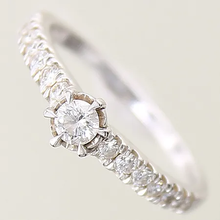 Ring med diamanter 1 x ca 0,16ct 14 x ca 0,01-0,02ct stl:16 bredd 1,5-5mm, vitguld 18K Vikt: 2,7 g