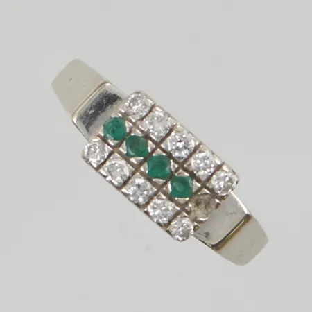Ring med diamanter 10x ca 0,03ct stl:18 bredd 8mm, slitna smaragder, en saknas 18K 3,8g.