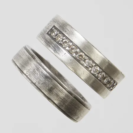 Två ringar, stl16¾, bredd 4,9-6,9mm, vita stenar, missfärgningar, personliga gravyrer, 925/1000 silver Vikt: 11,7 g