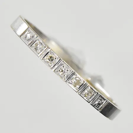 Ring med vita stenar stl:18¾ bredd 2mm, gravyr, vitguld, 18K. Vikt: 1,7 g
