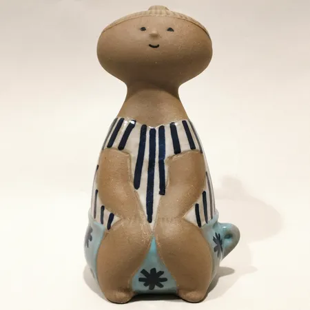 Figurin Lotta Lisa Larson för Gustavsberg, ur serien Larsons ungar, höjd 17cm, signerad Lisa L etikettmärkt, bemålad och glaserad stengods Skickas med postpaket.