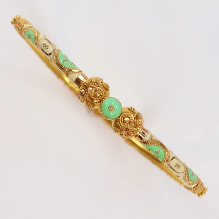 Armring med dekor av emalj öppningsbar Ø64mm bredd 3,7mm skev 21K.  Vikt: 10,7 g