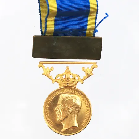 Medalj 23/18k. Vikt: 12,8 g