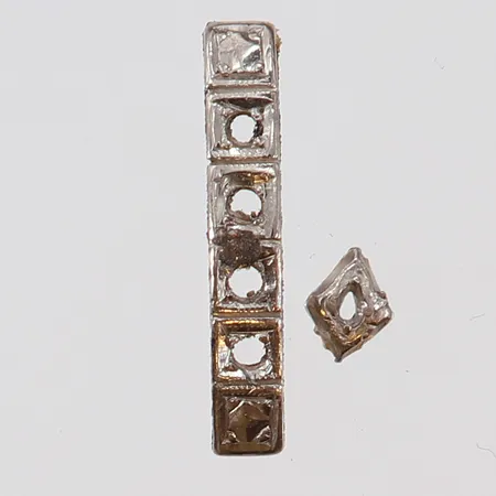 Guldskrot vitguld 18K.  Vikt: 0,3 g