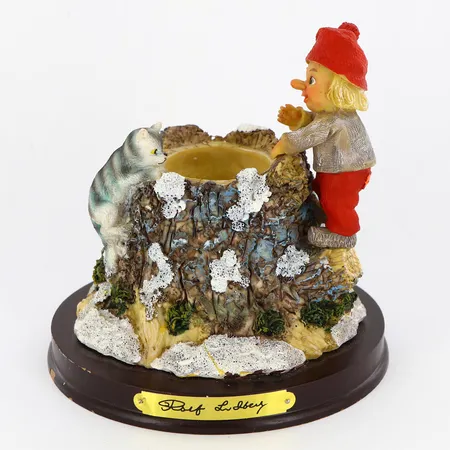 Figurin/ljusstake Rolf Lidberg höjd 14cm, plats för värmeljus, begränsad upplaga 0244/9000, träsockel med ställvis färgbortfall, originallåda.  Vikt: 0 g