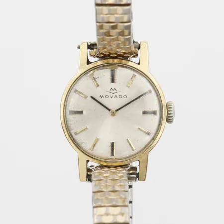 Damur Movado 18K, manuell, 19mm, plexiglas med repor samt spricka, gravyr, flexband i guldfärgat stål, inga tillbehör 