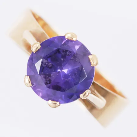 Ring med syntetisk färgad sten stl: ca 16½ bredd: ca 5-9mm 18K Vikt: 3,7 g