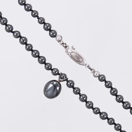 Collier med hematiter med hänge längd collier: ca 44cm Ø ca 4,2-4,5mm längd hänge: 13mm bredd: 8mm lås silver/metall Vikt: 0 g