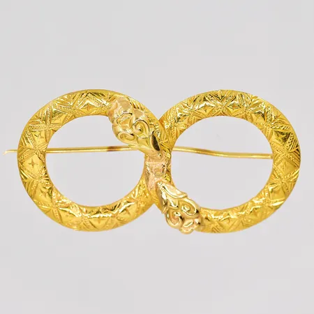 Brosch av omgjorda ringar längd 42mm graverad 20K nål 18K Vikt: 10,1 g