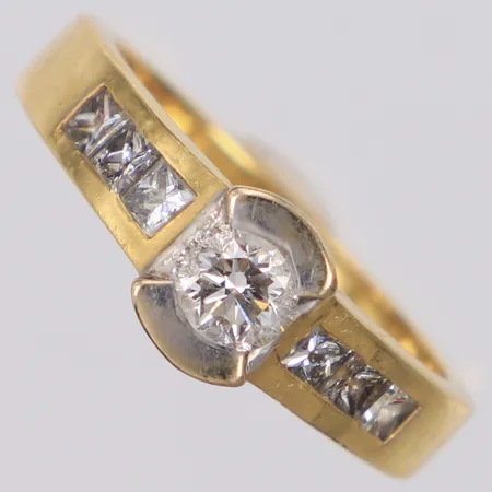 Ring med briljantslipad diamant 1xca 0,35ct samt prinsesslipade diamanter 6xca 0,05ct, stl 17¼, bredd 7,1mm, fattning i vitguld, smärre repor, 18K  Vikt: 5,4 g