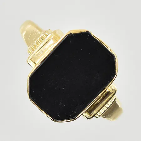 Klackring med onyx stl:19¼, bredd 2-13 mm, oval skena, 18K. Vikt: 3,3 g