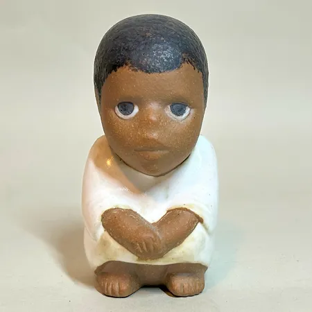 Figurin "Syd" Lisa Larson för Rörstrand, ur serien All världens barn, höjd 10,5cm, etikettmärkt, svaga stämplar, stengods 