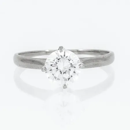 Ring med vit syntetisk sten Ø6,5mm stl:17 bredd 1-7,5mm, något naggade fasetter, 18K 2,4g. 