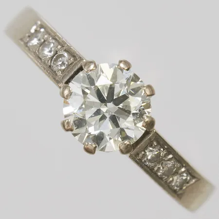 Enstensring med diamant 1 x ca.1,15ct, ca.TCr(I)/SI, mindre rondistskador samt 6 x ca.0,03ct, stl: 18½, bredd: 2,5-7,3mm, svenska stämplar, mindre repor, behov av rodiering, vitguld, 18K Vikt: 6,1 g