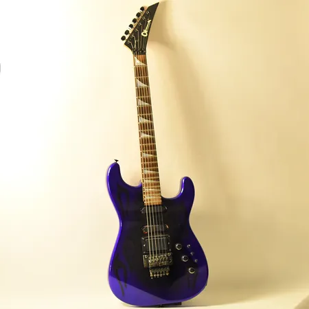 Elgitarr Charvel byJackson serienr 304817 1980-tal Fort Worth Texas, lila lack med flames, ytliga smårepor på kropp fram- och baksida, hårt originalcase. Skickas med postpaket.