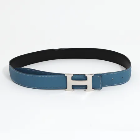 Bälte Hermès stl:90 vändbar i blått och svart med vita samt svarta stickningar, bredd:30mm, spänne i silverfärgad metall, märkt Hermès Paris made in France, bruksskick, del av kant med vikmärke, spänne med bruksrepor, originallåda.