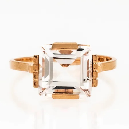 Ring i 18K guld med vit sten 10 x 10 mm. Den är i storlek 19, är 1,5 - 11 mm bred och väger 4,2g. Stämplad X8 (1948), TESI (Tenn & Silver AB, V. Frölunda), 18K, kattfot. Sten med naggade hörn, men fin lyster ändå.  