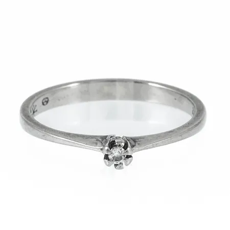 Stjärnringen Pallas i 18K vitguld med 1 x 0,02ct briljantslipad diamant. Den äri storlek 16½, är 2,2 - 3 mm bred och väger 1,7g. Stenstorlek 0,02ct ingraverad. Sämplad Stjärnringenstjärna, 18K, svensk importstämpel.