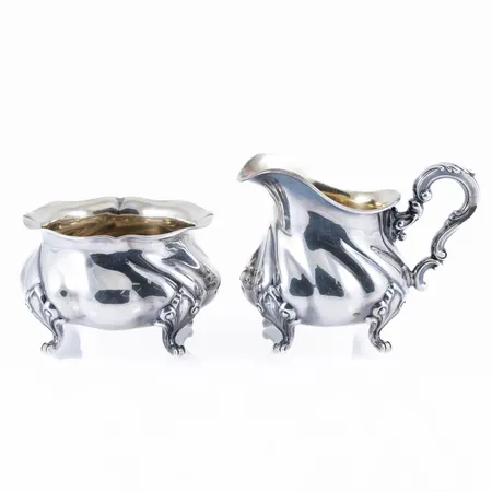 Sockerskål och gräddkanna i rokokostil. Höjd 55 - 80 mm. Silver 830/1000. Vikt: 206,2g. 