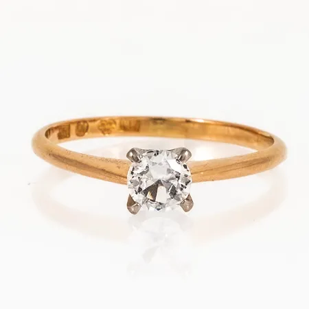 Ring i 18K röd- och vitguld med vit sten Ø 5 mm. Den är i storlek 19, är 1,8 - 5,5 mm bred och väger 2,6g. Stämplad FK (Kjellins AB, Umeå), 18K, kattfot.