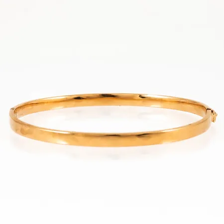 Armring i 18K guld. Innermått 18,5 cm, 61,5 x 52,5 mm, är 4,5 mm bred och väger 9,1g. Öppningsbar. Stämplad 18K, svensk importstämpel. Ett par bucklor förekommer. 