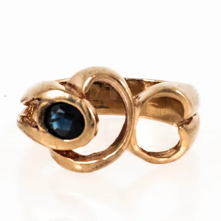 Ring i 14K guld: Genombruten dekor med en blå safir 5,5 x 4,5 mm. Den är i storlek 20, är 5 - 13 mm bred och väger 9,4g.  