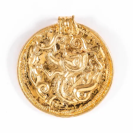 Hänge i 18K guld: kopia av Vikingasmycke funnet i Uppland, tillverkad av Bengt Hallberg, Köping. Det är Ø 37 mm och väger 17,5g. Tidigare broschnål borttagen. Mycket fint skick.