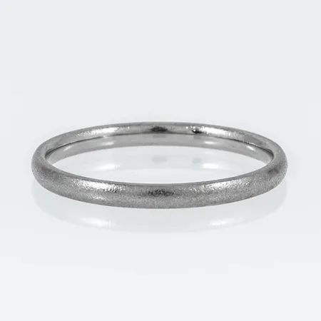 Ring i 18K vitguld. Den är i storlek 18½, är 2 mm bred, 1,4 mm hög och väger 2,2g. Matterad yta. Stämplad GIU (Guldsmedjan i Umeå AB), 18K, kattfot.