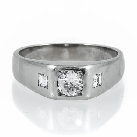 Klackring i 14K vitguld med en gammalslipad diamant c:a 0,50ct (c:a W/si),kulettfasett, två smaragdslipade diamanter c:a 2,8 x 2,5 mm. Den är i storlek 20¾, är 4 - 7,5 mm bred och väger 8,5g.  